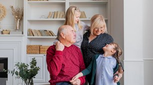 Großeltern mit ihren Enkelkindern Zuhause am lachen